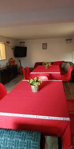 阿普里尔齐Къща за гости Вила Отдих Vila Otdih的一间房间,里面摆放着两张红色的桌子和鲜花