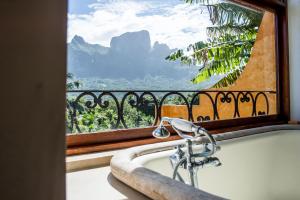 波拉波拉Villa Yrondi的浴缸位于享有美景的窗户前