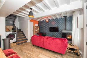 埃特勒塔L’Ancre des falaises - MAISON VUE MER & À 50M PLAGE (hypercentre)的一间带红色沙发的客厅和楼梯