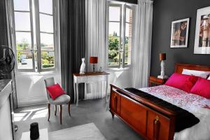 阿尔比LE CHERCHE MIDI Chambres d'hôtes avec CUISINE EQUIPEE grand jardin PARKING SECURISE GRATUIT的一间卧室配有一张床、一把椅子和窗户。