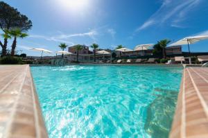 普罗奇达Insula Boutique Hotel的一个带蓝色水和白色遮阳伞的游泳池