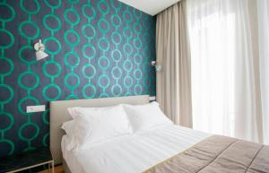 利多迪卡马约雷Hotel Medusa的一间卧室设有一张床和蓝色的墙壁