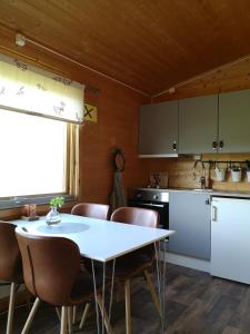 KjøllefjordDavvi Siida - Reindeer Design Lodge的厨房配有白色的桌椅、桌子和柜台。