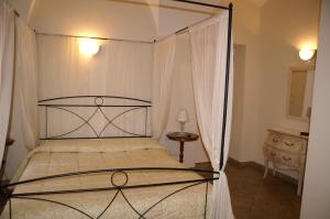 Busca波塔圣玛丽亚酒店的一间卧室配有一张带金属天蓬的床