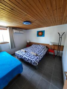 SappirSapir Apartment的一间卧室设有两张床和木制天花板