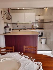 阿索马达VV - Casa Para Ti的厨房配有白色橱柜和木桌