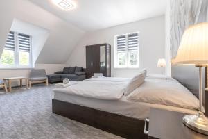 豪伊杜索博斯洛Panzió 81的白色卧室设有一张大床和一张沙发