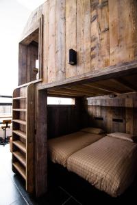 胡法利兹Café Coureur Houffalize的一间卧室配有双层床和木墙