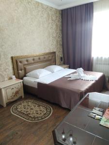 乌曼岛Uman Hotel的酒店客房配有一张床铺和一张桌子。