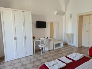 帕拉比塔B&B Il Ventaglio的一间卧室配有一张床、一张书桌和一台电视。