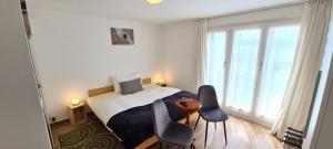 Praz卡维贝尔沙湾酒店及餐厅的一间卧室配有一张带两把椅子和一张桌子的床。