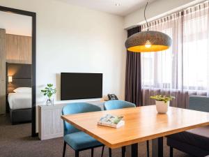 阿姆斯特尔芬阿姆斯特丹城南阿达焦酒店的一间带桌椅的房间和一间卧室