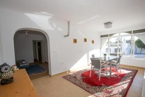 穆特克萨梅尔Apartment Costa Blanca的一间设有桌子和红色地毯的用餐室