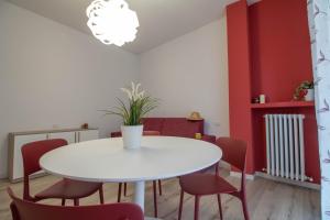 莱科Le Casette Di Osvaldo的一间设有白色桌子和红色椅子的用餐室