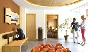 卡斯特尔罗托玛蒂娜住宿加早餐旅馆的两个女人站在一个有一堆苹果的房间