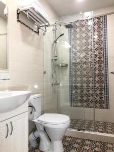 撒马尔罕Sabrina Hotel的带淋浴、卫生间和盥洗盆的浴室