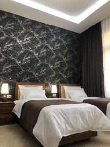 撒马尔罕Sabrina Hotel的一间卧室设有两张床和黑色的墙壁