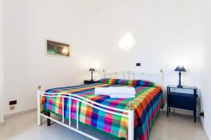 圣维托罗卡波Villa Ciuri di fronte al mare的一间卧室配有一张色彩缤纷的床和2个床头柜。