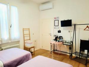 博洛尼亚Stop Over BLQ的客房设有两张床、一张桌子和一台电视。