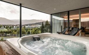 布鲁尼科Bellevue Bruneck - Suites & Lofts的窗户房屋内的浴缸