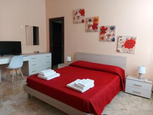 雷焦卡拉布里亚Arte Mia B&B的一间卧室配有一张红色的床、一张桌子和一台电脑