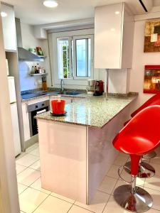 锡切斯Los Globos Beach Studio by Hello Homes Sitges的厨房配有红色椅子和柜台