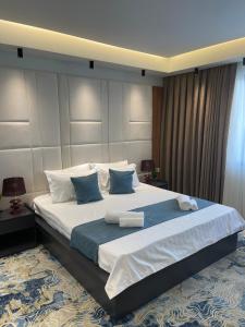 盖夫盖利亚Apartments Jordan Luxury的一间卧室配有一张带蓝白色枕头的大床