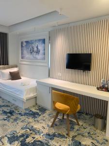盖夫盖利亚Apartments Jordan Luxury的一间卧室配有一张床、一张书桌和一台电视。