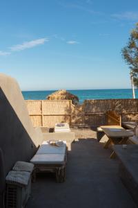 佩里萨Demilmar Luxury Suites的一个带沙发和桌子的庭院,享有海景。