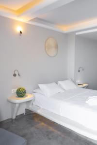 佩里萨Demilmar Luxury Suites的白色卧室配有床和桌子
