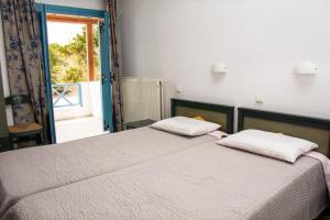 皮萨瑞弗罗达艾日达别墅公寓式酒店的一间卧室配有带两个枕头的床和窗户