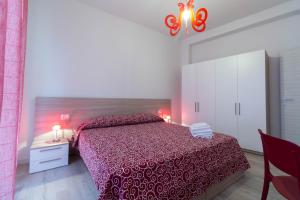 莱科Le Casette Di Osvaldo的一间卧室配有一张红色床罩的床