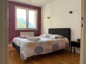 圣克洛德La BELLE VUE的一间卧室配有带两个枕头的床和窗户