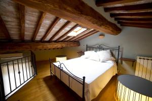 蒙塔尔奇诺Colle al Matrichese - Historic Winery的一间带一张床的卧室,位于带木制天花板的房间内