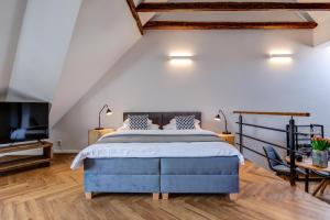 波杰布拉迪Design Pension Twenty 20的一间卧室配有蓝色的床和电视