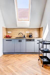 波杰布拉迪Design Pension Twenty 20的厨房配有白色橱柜和天窗。