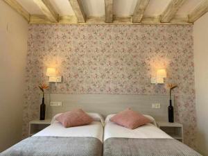 PoveñaCasa Rural Mugarri的一间卧室设有两张床和鲜花墙