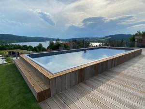 伏尔塔瓦河畔利普诺JBX Resort Apartments Lipno的湖景甲板上的游泳池