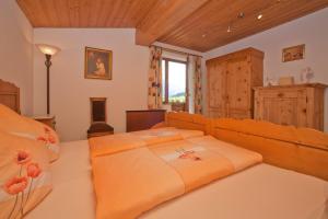 蒂罗尔州基希多夫Ferienwohnungen Schneider的一间卧室配有一张带橙色床单的大床