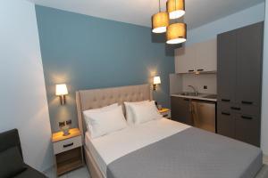 阿穆迪亚科勒套房酒店的一间带白色床的卧室和一间厨房