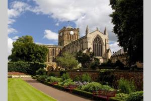 赫克瑟姆Hexham Town Centre, Market Place View的一座带钟楼和花园的建筑