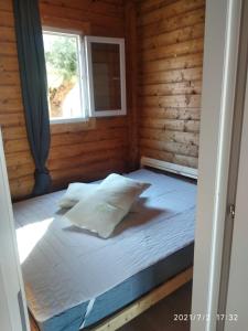 奥托纳Camping Borghetti的木制客房的一张床位,设有窗户