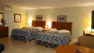 布克塔谢Bouctouche Bay Inn的酒店客房设有两张床和一张桌子。