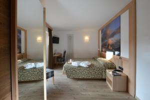 瓦雷纳艾尔皮诺酒店的酒店客房,设有两张床和镜子