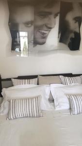奥斯图尼Casa di Anna的卧室配有一张白色床,墙上挂有两张照片
