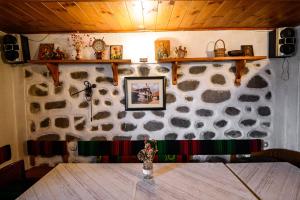 班斯科Къща за гости Даутев Връх的客房内的石墙和桌子