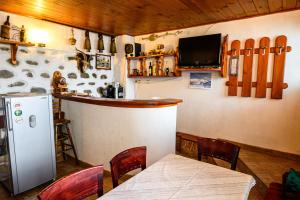 班斯科Къща за гости Даутев Връх的厨房设有带桌子和冰箱的酒吧