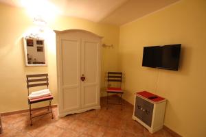 努奥罗马约雷住宿加早餐旅馆的一间设有两把椅子和一台平面电视的房间