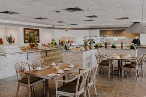 梅里达Hotel Los Aluxes的一间带木桌椅的餐厅和一间厨房