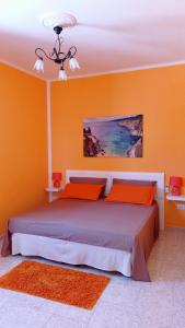 迪索Casa vacanze Salento的一间卧室配有一张带橙色墙壁的大床